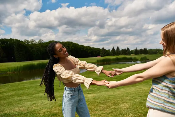 Dos jóvenes abrazan el calor de un día soleado en el parque, compartiendo sonrisas y risas. - foto de stock