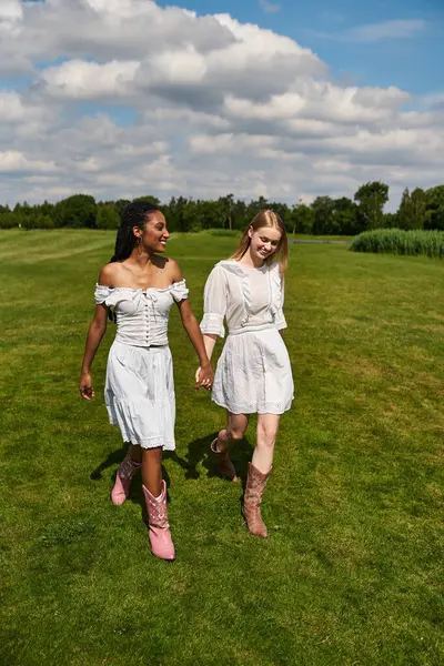 A joyful couple walks in a lush field on a sunny day, radiating love and happiness. — Stock Photo