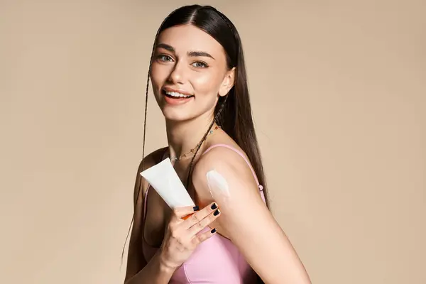 Una giovane donna allegra applica la protezione solare sulla sua pelle baciata dal sole, abbracciando le vibrazioni estive.. — Foto stock