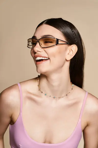 A joyful woman with a sun tan wears trendy sunglasses, radiating happiness in summer warmth. — Stock Photo