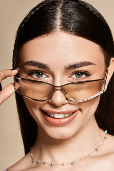 A young woman sports stylish sunglasses and a radiant smile on a sunny day. — Stock Photo
