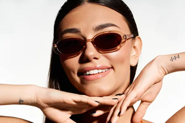 Young woman radiates joy and confidence while embracing sunny summer days with sunglasses. — Stock Photo
