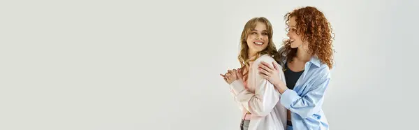 Две женщины выражают свою привязанность друг к другу, тепло улыбаясь в уютном, хорошо освещенном пространстве.. — стоковое фото
