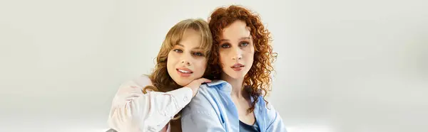 Zwei junge Frauen umarmen sich freudig und lächeln in einer warmen, liebevollen Atmosphäre. — Stockfoto