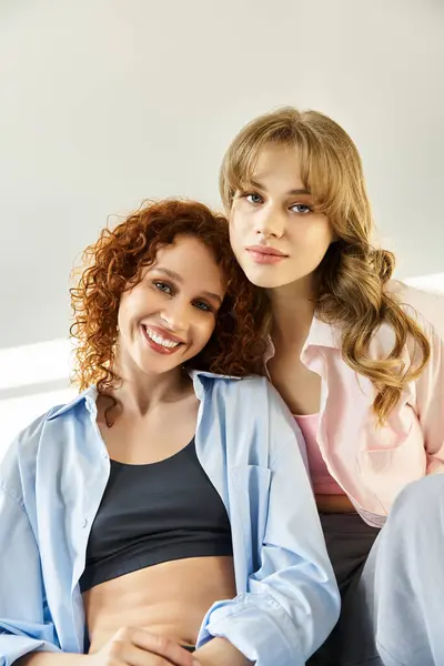 Two young women share a loving embrace, radiating joy and happiness in a warm, illuminated setting. — Stock Photo