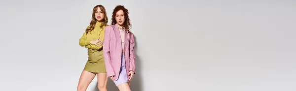 Two young women embrace their love and confidence while posing in chic outfits for a vibrant photo. — Stock Photo