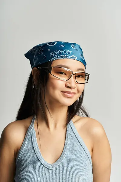 Une jeune belle femme asiatique met en valeur son style avec un bandana tout en souriant avec confiance. — Photo de stock