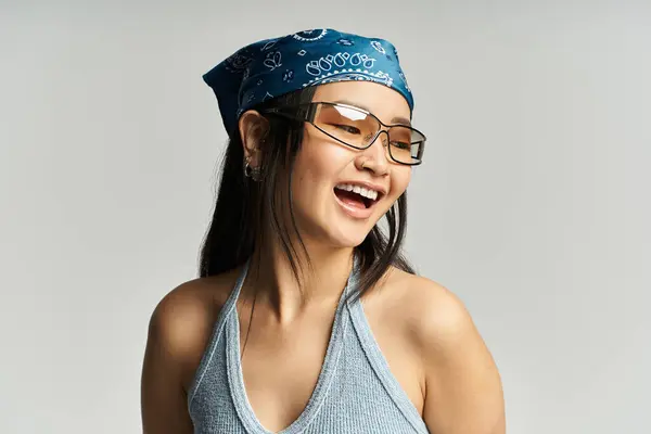 A young, beautiful Asian woman smiles happily in a trendy outfit with stylish accessories. — Stock Photo