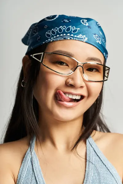 Bright and cheerful young woman showcases her playful spirit while wearing a bandana and glasses. — Stock Photo