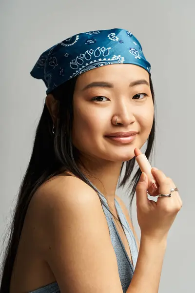 Eine junge Asiatin lächelt, als sie ihre Make-up-Fähigkeiten in einem modernen Studio präsentiert. — Stockfoto