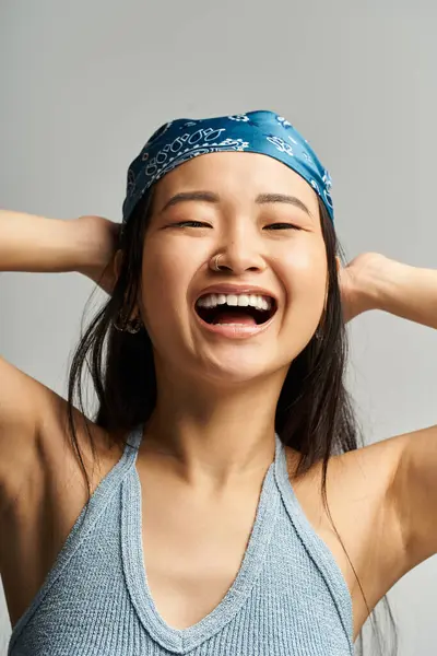 Young beautiful woman with long hair and a blue headband radiates happiness while posing playfully. — Stock Photo