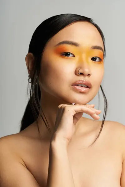 Jeune belle femme asiatique met en valeur le maquillage vibrant tout en posant en toute confiance avec le flair artistique. — Photo de stock