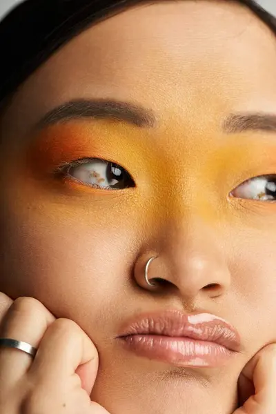 Una giovane donna asiatica con un trucco sorprendente mette in mostra le sue emozioni mentre posa pensieroso, in casa. — Foto stock