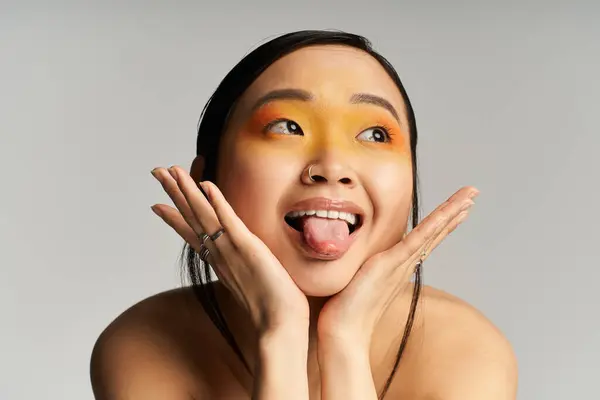 Joyful young asian woman showcases her playful spirit with colorful makeup and a bright smile — Stock Photo