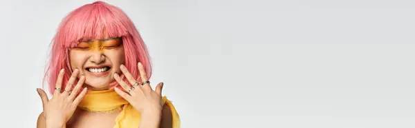 Eine fröhliche junge Asiatin mit pinkfarbenen Haaren und lebendigem Make-up strahlt Glück aus. — Stockfoto