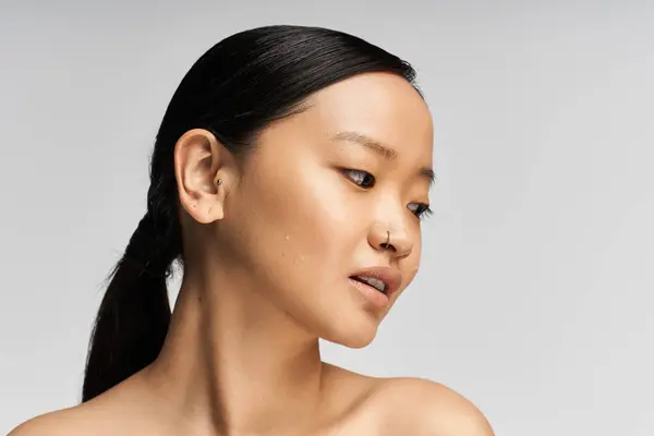 Uma jovem mulher asiática irradia beleza e graça em um ambiente suave e elegante. — Fotografia de Stock
