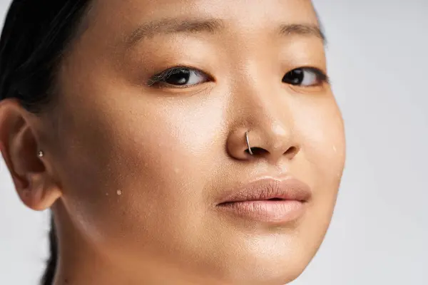 Una giovane donna asiatica mette in evidenza la sua bellezza naturale con fiducia nella luce soffusa. — Foto stock