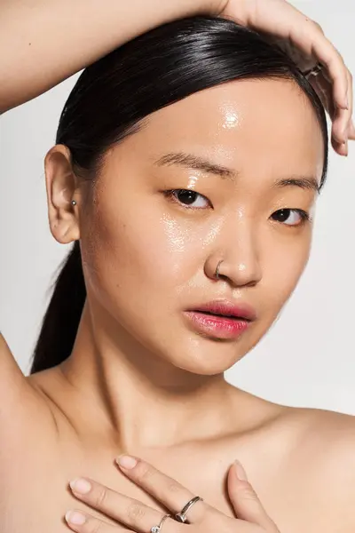 Una giovane donna asiatica posa con grazia, mostrando la sua bellezza naturale e la pelle radiosa. — Foto stock