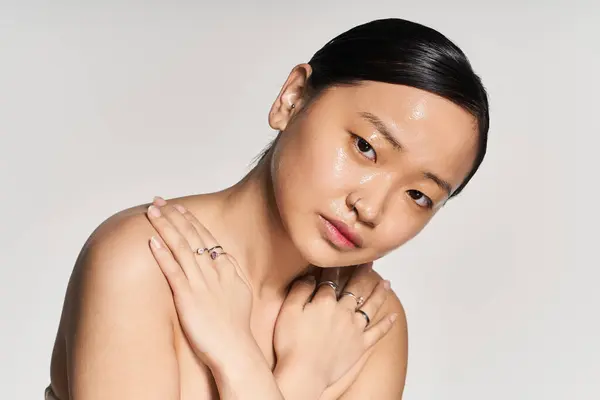 Une jeune femme asiatique pose gracieusement, montrant sa beauté naturelle et ses bijoux. — Photo de stock