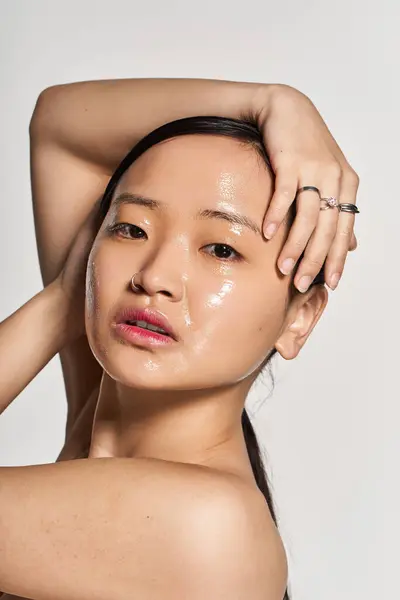 A young Asian woman highlights her beauty with radiant skin in a stylish pose. — Stock Photo