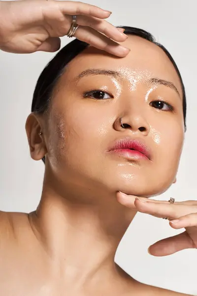 Una giovane donna asiatica mette in mostra la sua routine di cura della pelle, evidenziando la sua carnagione radiosa. — Foto stock