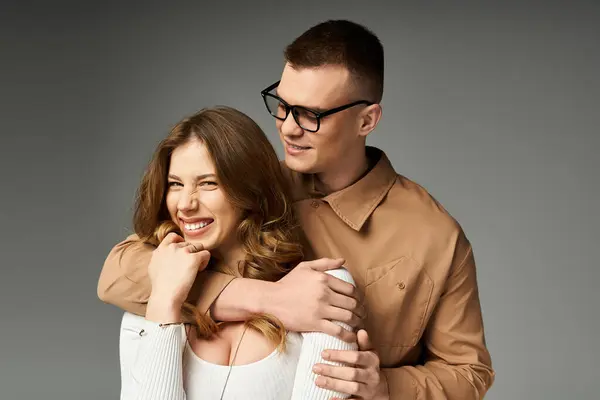 A stunning couple shares a joyful moment, showcasing their elegance and love in a charming embrace. — Stock Photo