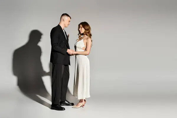 Beautiful bride and groom share a loving moment, holding hands in an intimate atmosphere together. — Stock Photo