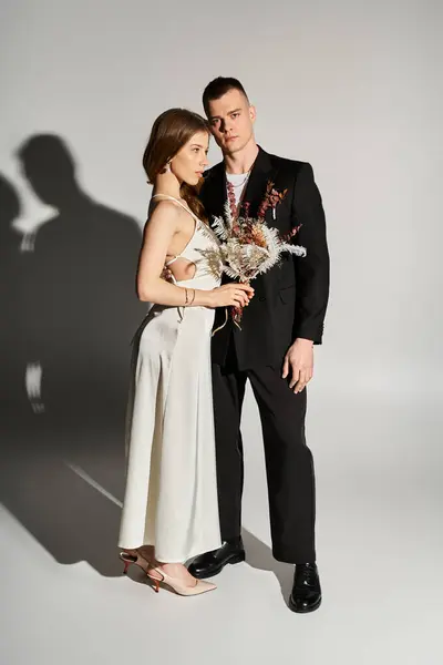A beautiful couple stands together, radiating love and elegance in a contemporary environment. — Stock Photo