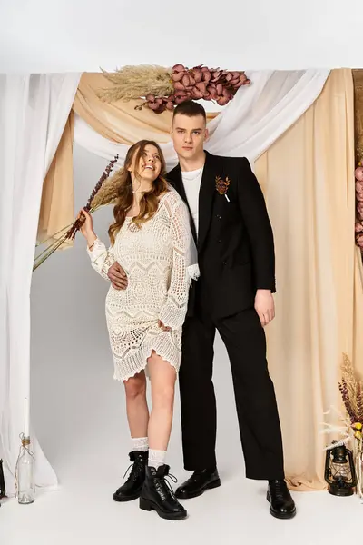 A stunning couple stands together, exuding elegance and romance in a beautifully adorned backdrop. — Stock Photo