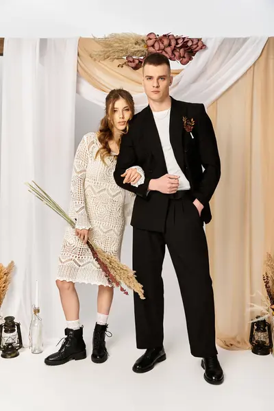 A lovely bride and groom pose romantically in a stylish, floral decorated venue. — Stock Photo