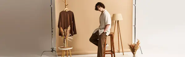 A young man showcases a trendy summer outfit, highlighting his curls in a chic studio space, banner — Stock Photo