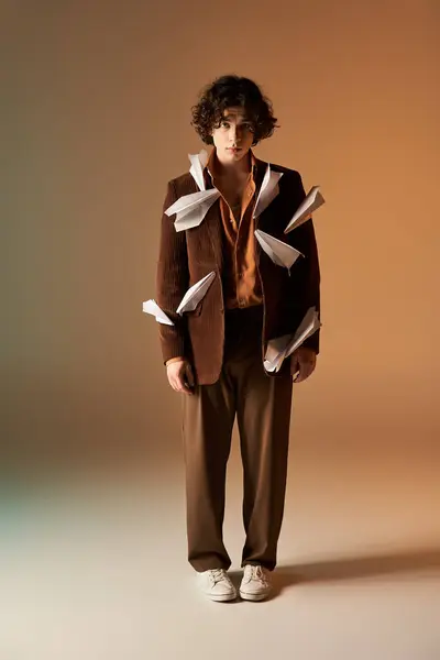 A young man confidently wears a playful brown corduroy blazer with paper planes. — Stock Photo