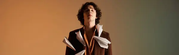 Young man in a brown corduroy blazer stands confidently with paper planes around him, banner — Stock Photo