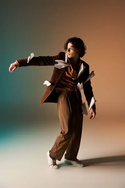 A young man with curly hair showcases a fun and quirky outfit featuring paper planes. — Stock Photo