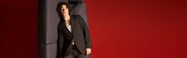Charming young man with curly hair showcases his fashion sense in a sleek studio setting, banner — Stock Photo