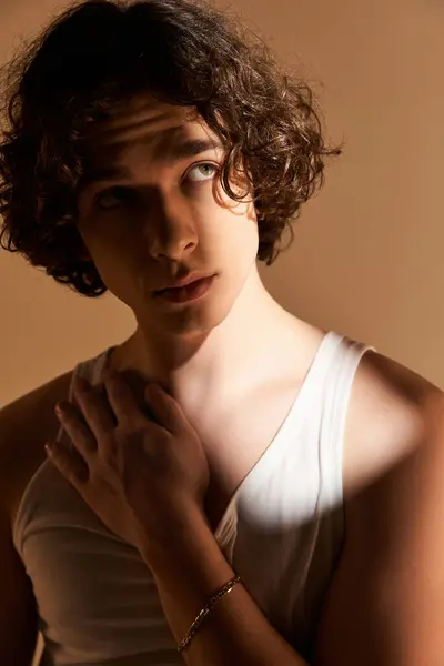 A young man with vibrant curls showcases his unique style in a cozy studio atmosphere. — Stock Photo