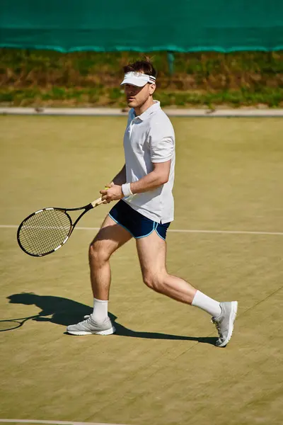 Un jugador experto en ropa deportiva blanca muestra su talento en una pista de tenis brillante. - foto de stock
