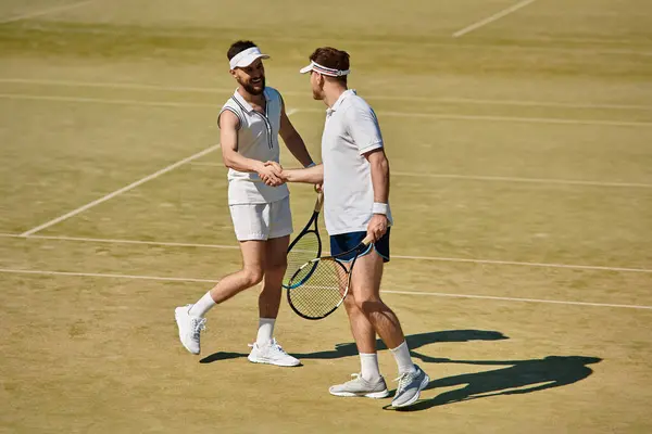 Two skilled players engage in a joyful tennis match, shaking hands after a point on the court. — Stock Photo
