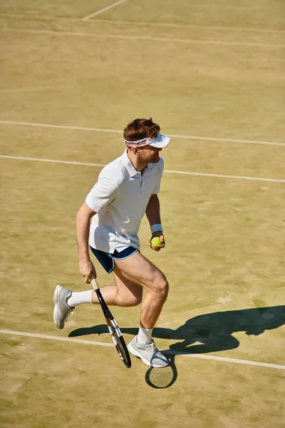 Un jugador experto corre a través de la cancha, listo para servir mientras el sol brilla intensamente durante el verano. - foto de stock