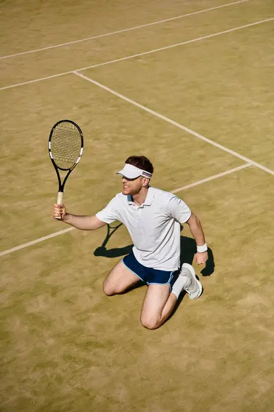 Un jugador experto realiza un movimiento de tenis dinámico en una cancha iluminada por el sol con ropa deportiva blanca. - foto de stock