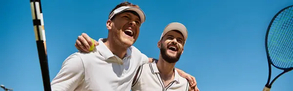 Two athletes celebrate their summer match with smiles and camaraderie on the tennis court, banner — Stock Photo