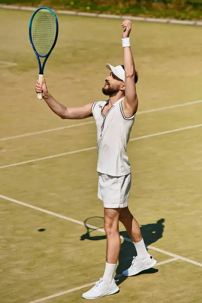 A young man in white sportswear celebrates a successful shot while playing tennis in warm weather. — Stock Photo