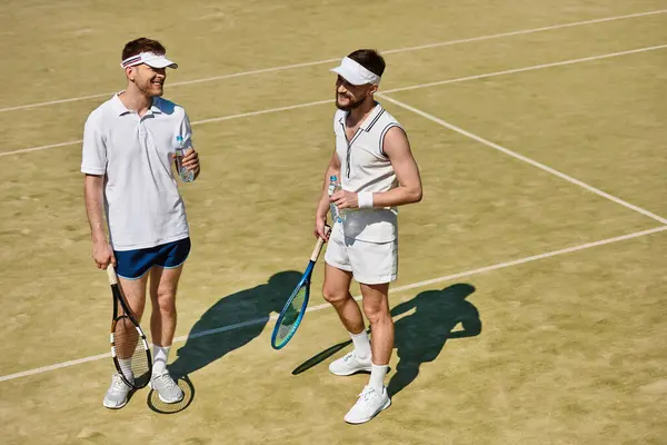 Two men are playing tennis on a warm summer day, smiling and sharing moments of joy together. — Stock Photo