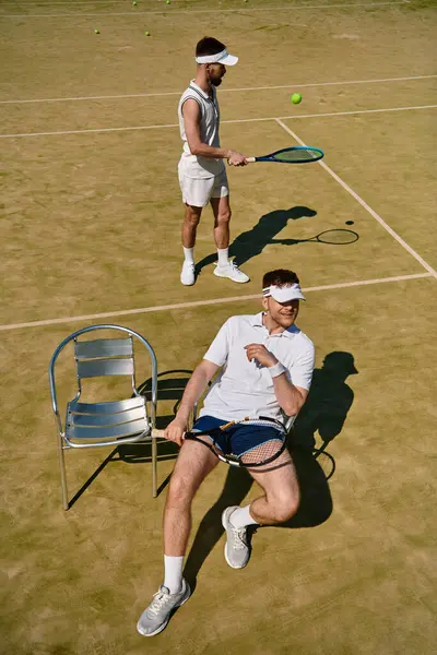 Two handsome men practice their tennis skills on a warm summer day at the court. — Stock Photo