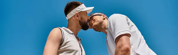 Two men share a tender moment at a sunny tennis court while playing summer sport, banner — Stock Photo