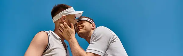 Two young men play tennis, exchanging smiles and kisses under the sun, banner — Stock Photo