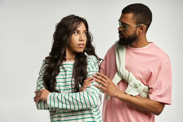 A fashionable duo engages in a meaningful exchange, showcasing their unique style and connection. — Stock Photo