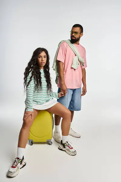 Trendsetting couple poses confidently with luggage, embodying love and contemporary style together. — Stock Photo