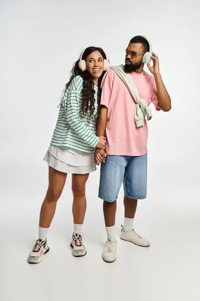 A couple enjoys a lighthearted moment, dressed in trendy outfits, radiating love and joy. — Stock Photo