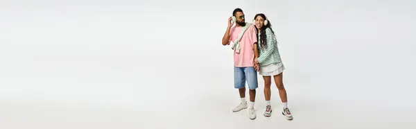 Paar drückt Liebe und Modebewusstsein vor sauberem, zeitgenössischem Hintergrund aus. — Stockfoto